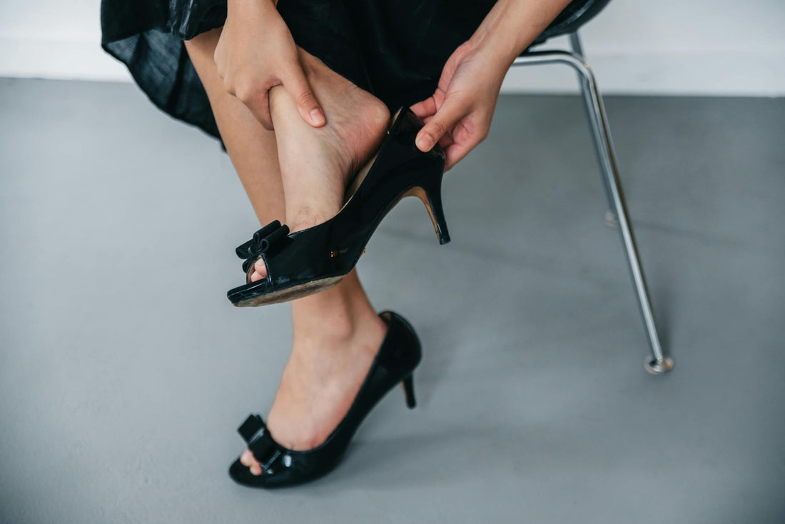 A woman removing an uncomfortable work shoe